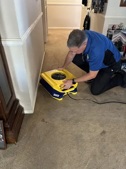 A technician extracting standing water from a flooded floor in an Elkridge, MD home